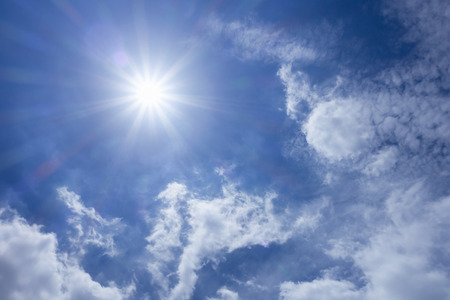 Strong sun in blue sky and white cloudsの写真素材