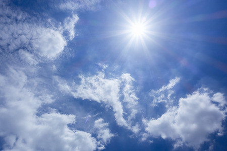 Strong sun in blue sky and white cloudsの写真素材