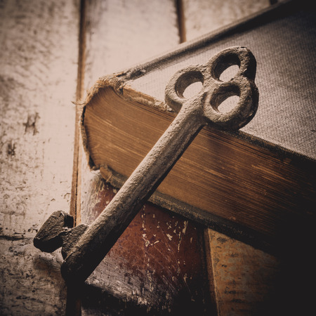 Rusty old key place on the book and wooden table, still lifeの写真素材