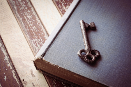 Rusty old key place on the book and wooden table, still lifeの写真素材