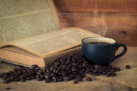 Coffee cup and coffee beans on old wooden backgroundの写真素材