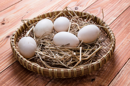 Duck eggs in the basket on wooden tableの写真素材