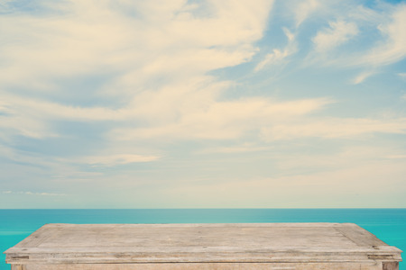 Empty top of wooden table or counter and blured image of tropical beach. For product displayの写真素材