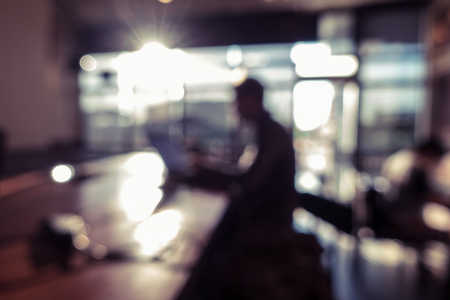 silhouette man using laptop computer working in coffee shopの写真素材