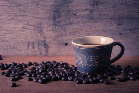 Coffee cup and coffee beans with stream on old wooden backgroundの写真素材