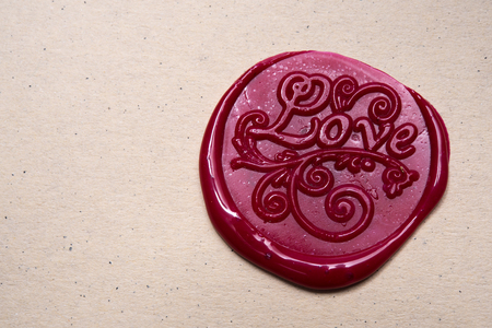 Love letter and ornament on red wax seal over brown paper with copyspaceの写真素材