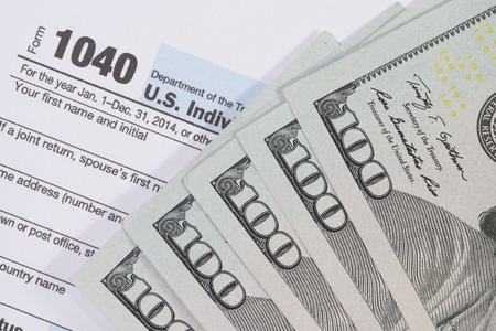 The dollar banknotes with tax form for business and finance conceptの写真素材