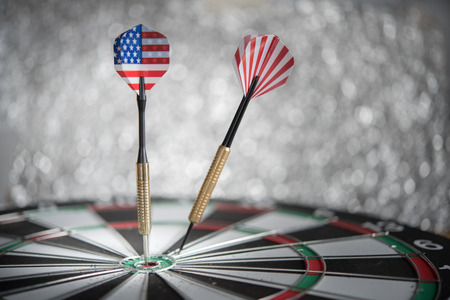 dart arrow hitting in the target center of dartboard with defocus or blurred background, concept for business achieve or beat the target concept for business achieve or beat the targetの写真素材