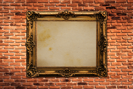 Gold vintage frame isolated on old brick wall backgroundの写真素材