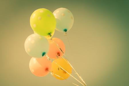 Colorful balloons on blue sky background in vintage color styleの写真素材