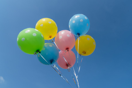 Colorful balloons on blue sky background in vintage color styleの写真素材