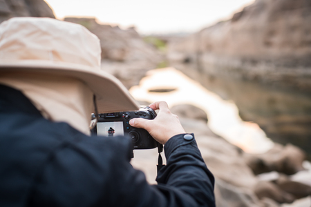 Back view of photographer while shooting image, selective focus on camera screenの写真素材