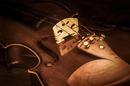Art. Closeup of old wooden violin stringed instrument on old wooden table. Classical music.の写真素材