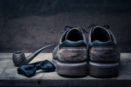 Brown shoes of daddy on on wooden table, bar or counter over brown wood wall background, fathers day conceptualの写真素材
