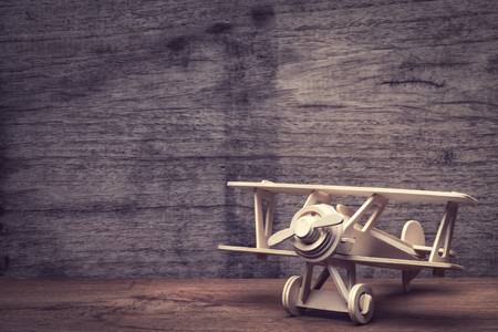 Wooden airplane toy place on grunge wood table, vintage style effect.の写真素材