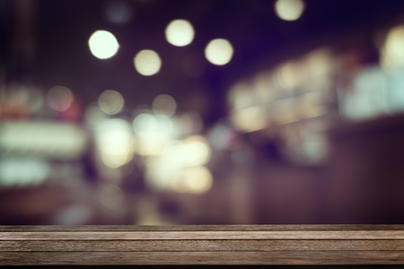 Wooden empty table top with defocus of pub or restuarant or cafeteria with bokeh light background, use for montage or product display, business conceptの写真素材