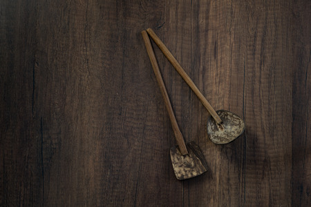Pair of wooden spoons made from coconut shell on dark wooden table backgroundの写真素材
