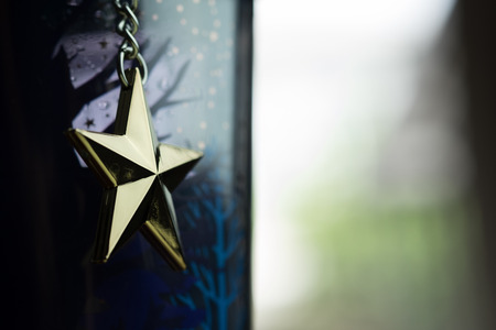 Golden star hang on chain with bright vintage backgroundの写真素材