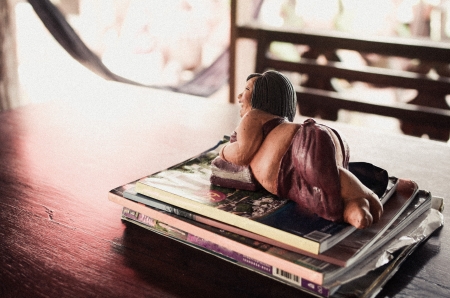 Ceramic fat woman lay on bookの写真素材