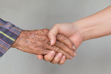 Senior woman and young woman holding hands の写真素材