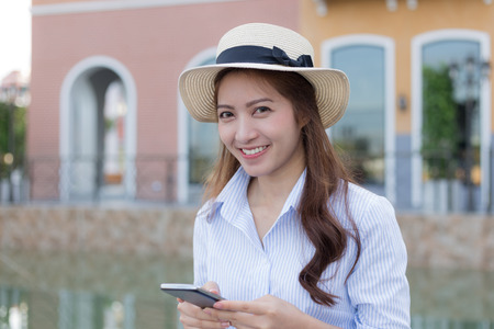 Young Asian woman with smiling face using smartphoneの写真素材