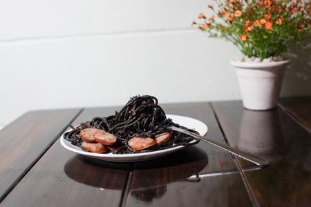 spicy squid ink spaghetti with sausageの写真素材