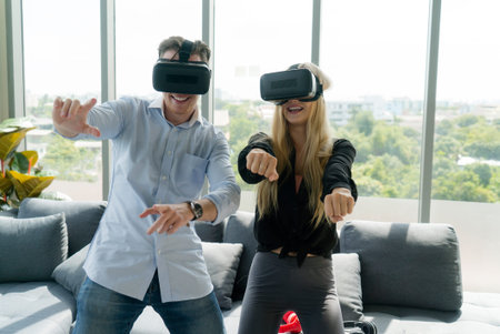 Happy young couple playing video games with virtual reality glasses at home.