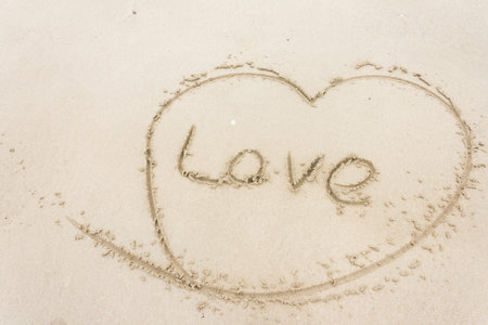 draw heart and write the word love on the sand