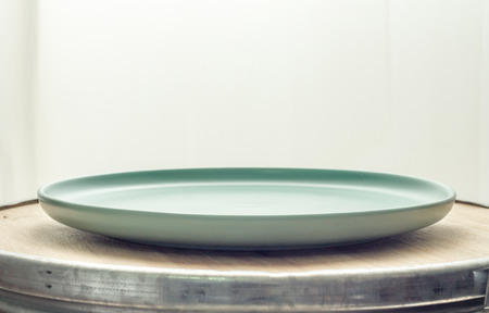 ceramic plates on wooden background with light curtainの写真素材