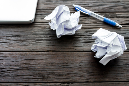 Working with crumpled paper, notebook and pen on wooden table backgroundの写真素材