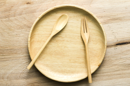 top view of plate, spoon and fork on wood backgroundの写真素材