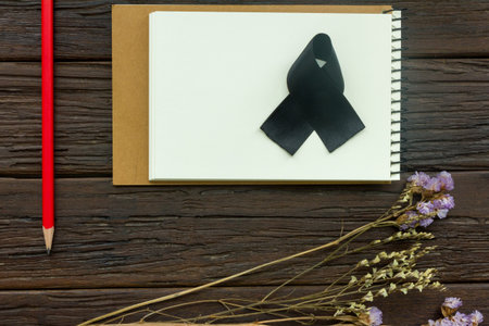note book with red pencil and flower statice on wooden background, copy space