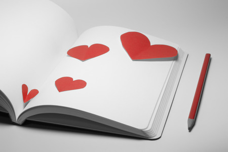diary and pencil with paper heart on white backgroundの写真素材
