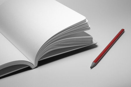 note book with red pencil on white backgroundの写真素材