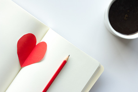 coffee cup diary pencil and  red heart on white backgroundの写真素材