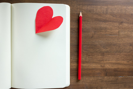 diary, pencil and  red heart on wooden bacgroundの写真素材