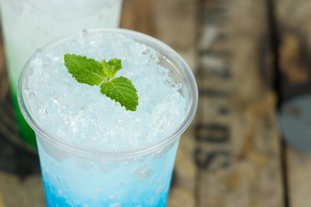 italian soda with mint leaves on ice, colorful of fruit juice on wooden tableの写真素材