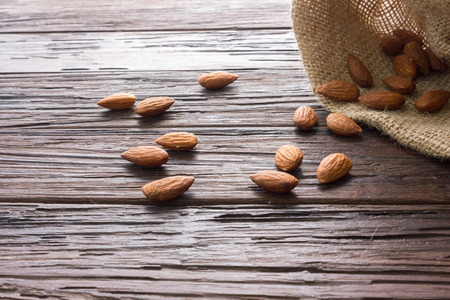 almond seed with sack on brown wooden background texture have copy space easy to use for graphic workの写真素材
