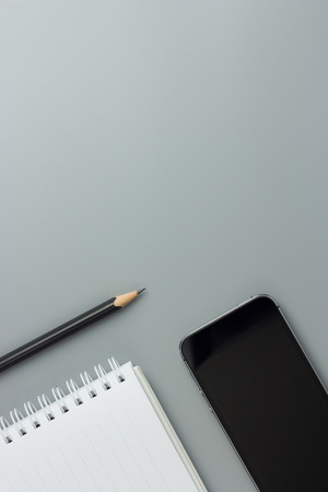 pencil and smartphone with book on gray background have copy space, top viewの写真素材