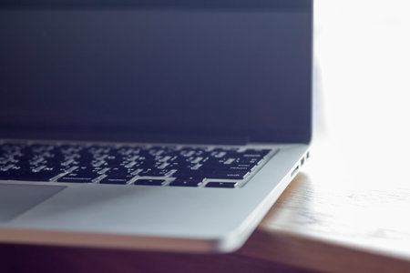 computer laptop on wooden table with window light