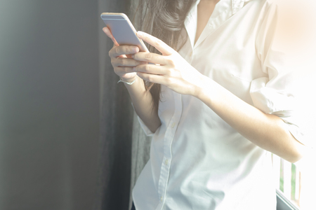 Close-up of female hands using smart phoneの写真素材