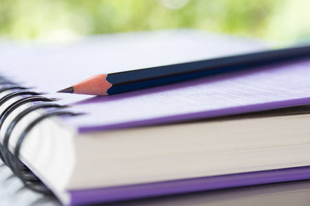 Notebooks and pencil over nature green backgroundの写真素材