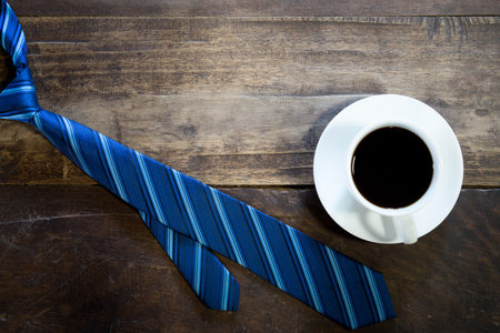 Coffee and necktie on wooden table.の写真素材