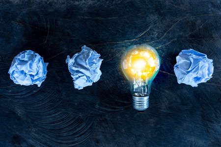 great idea concept with crumpled office paper and light bulb on table	の写真素材