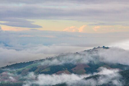 Fog on the mountain with morning sky in countryside of Thailandの写真素材