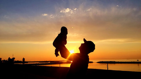 Silhouette of happy father playing with Son at the beach.の写真素材