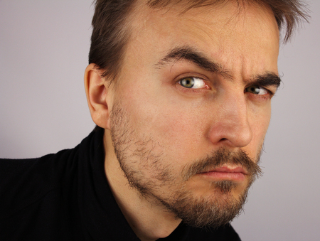 portrait of a man, suspicious look, closeup, studioの写真素材