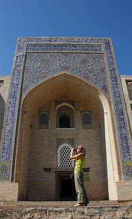 girl photographer take a picture in arch of Nodir-Devon-Begi madrasah, Bukhara, Uzbekistanの写真素材