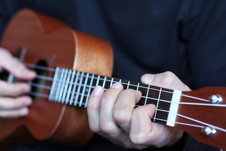 close up ukulele fretboard in musician hands, small depth of fieldの写真素材