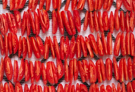 sliced red tomatoes, stacked in rows, ready to salad or to dry and dehydrated, top view, closeupの写真素材